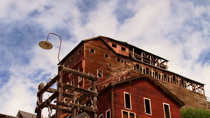 Low angle static shot time lapse of clouds looking up at the Concentration Mill building of the historic Kennecott Mine, located near the Kennicott Glacier, McCarthy, Alaska. 