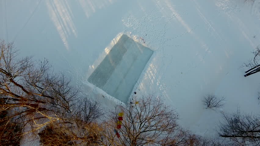 Aerial flyover a small ice rink on a small lake