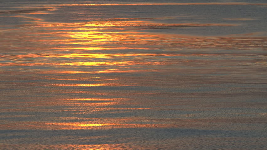 A strikingly rich sunset of very cold water sluggishly moving because of a thin
