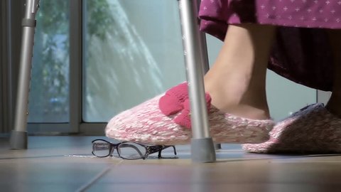 Elderly old woman feet slipping and falling down closeup 