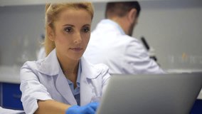 Mindful female researcher helping colleague with experiment