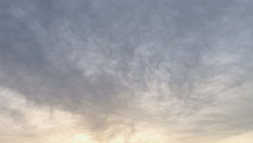Overcast sky during sunset, wisps of cloud moving diagonally to the overcast
