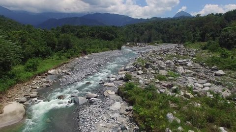 aerial view of mountain river flowing across tropical hills and boulders in Kota Belud Sabah Malaysian Borneo. Footage