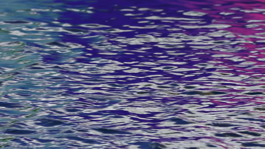 Slow pan in slow motion past multicolored rippling water.