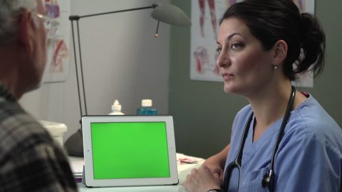 Doctor discussing results with patient on tablet, green screen Video de stock
