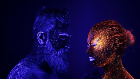 A man and a woman in the ultraviolet light caress each other. Fire and ice, two hypostases.