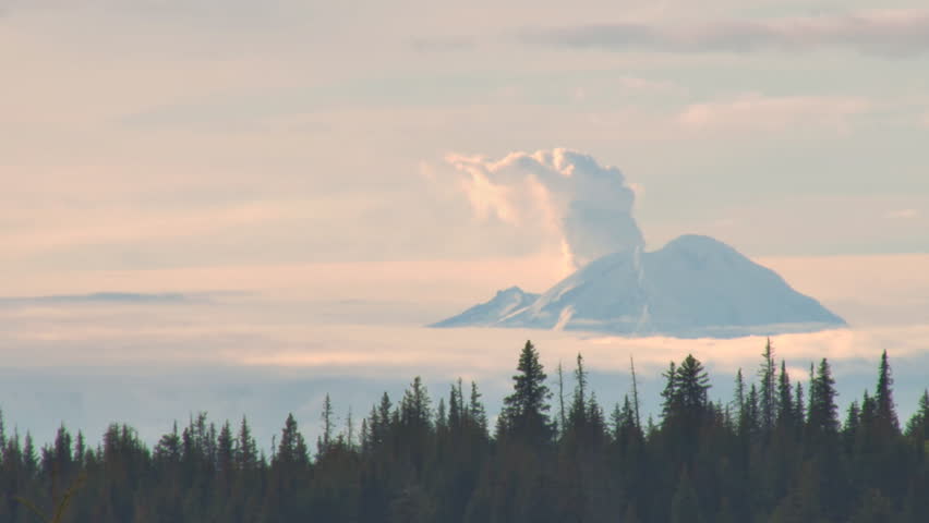 A timelapse of a conical volcano in Alaska (Mt. Redoubt) spewing steam with low