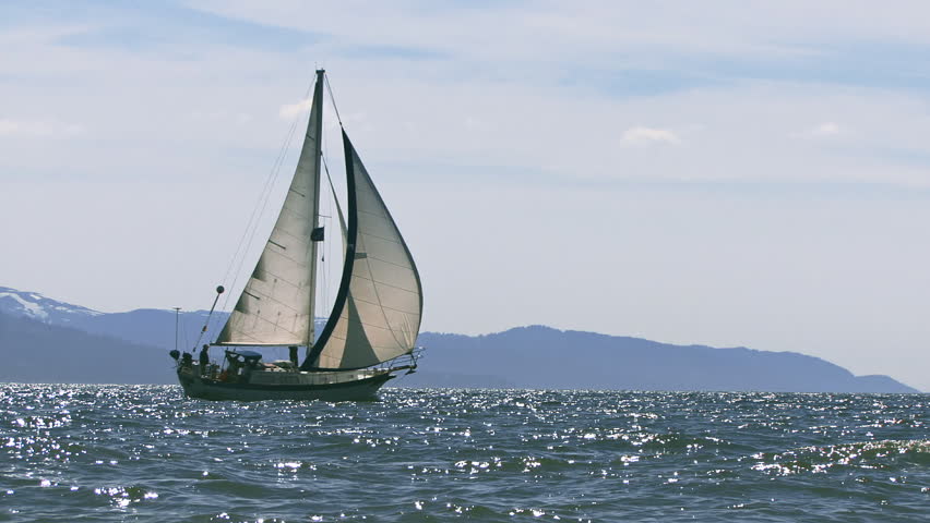 A sailboat, either cutter or masthead sloop, under way across the glistening