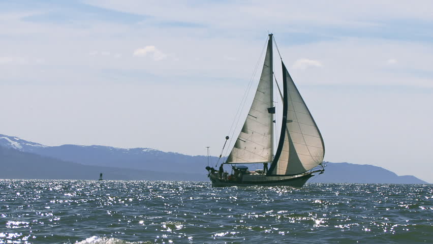 Reverse zoom from a medium framing of a sailboat, either cutter or masthead