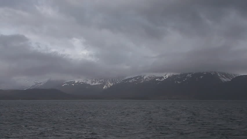 Pan to wide view of mountains and clouds over Resurrection Bay out of Seward,