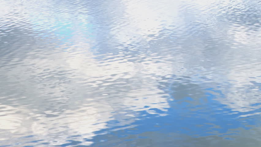Multi-faceted reflection of clouds and sky on a wind-rippled lake surface.
