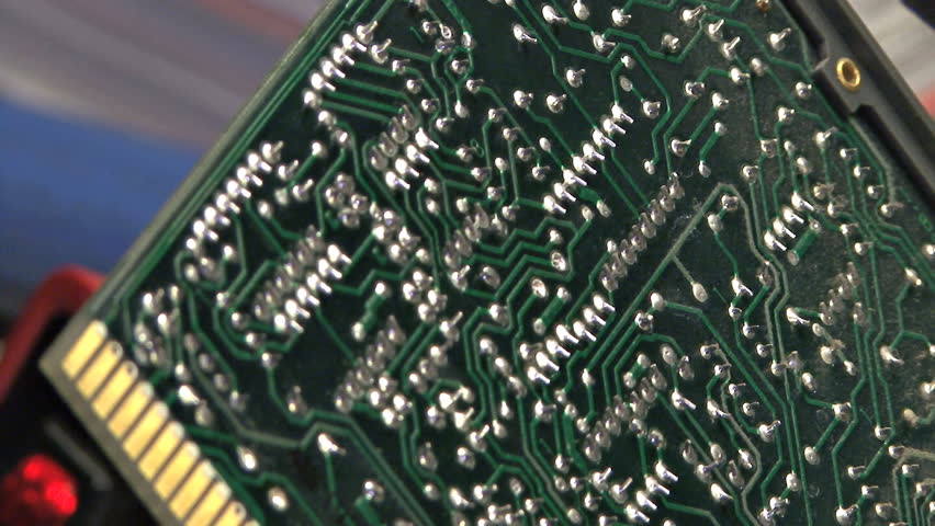 Close-up of a technician's actions - heating solder joints on a printed circuit