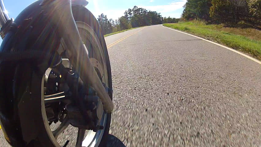 A point of view shot of a speeding motorcycle with the camera places just behind