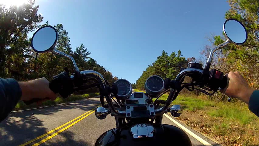 A wide angle point of view shot of a motorcycle climbing a steep and forested
