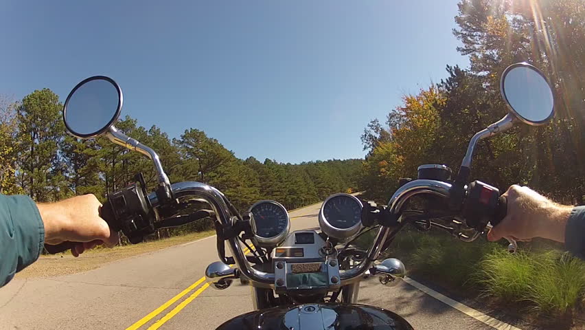 A wide angle shot of the point of view of someone riding a motorcycle on a