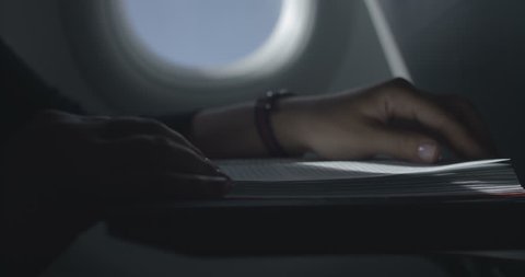 A woman reads a book in the airplane