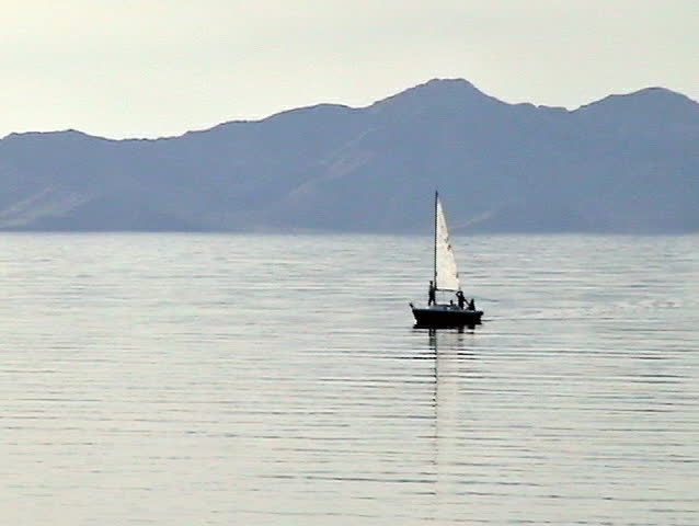 sailboat motoring on the Great Salt Lake. Family standing on deck. 