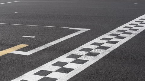 Checkered line and number one sign closeup on racing motorsport track, blurred cars crossing finish line symbol of win, end of the race, first position