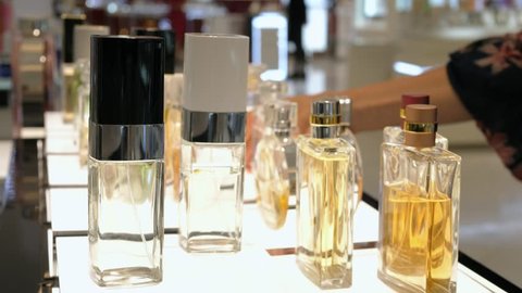 Female Hand Choosing Luxury Parfume In Cosmetic Store. Closeup. 
