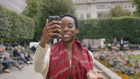 Attractive young black woman using her phone to record herself for social media