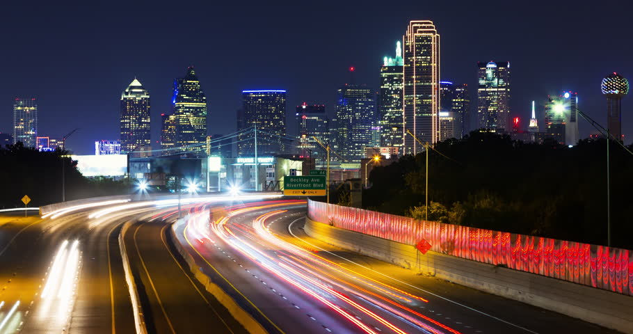 Dallas Skyline at Night Time-lapse. a time-lapse of the Dallas, Texas skyline at night with traffic light streaks on the highway and buildings in the background
