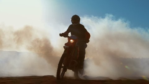 Professional Motocross FMX Motorcycle Rider Drives Through Smoke and Mist Over the Dirt Road Track. Shot on RED EPIC-W 8K Helium Cinema Camera.