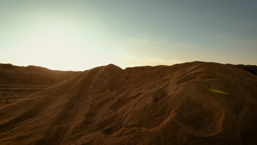 Professional Motocross Motorcycle Rider Jumping Over the Dune and Further Down the Off-Road Track. It