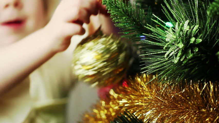 Little blonde girl decorates the Christmas tree
