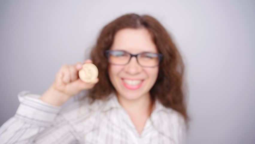 Happy woman holding a Golden Bitcoin