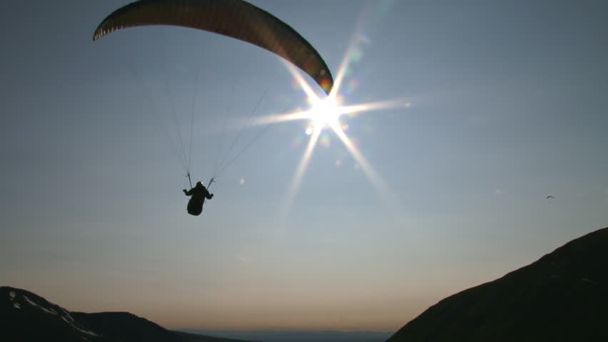 Almost like floating in space, a paraglider moves smoothly through the air,