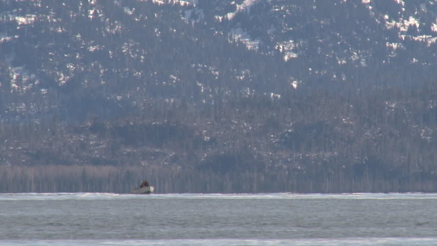 A very small-looking open skiff on the dynamic waters of Kachemak Bay, heading