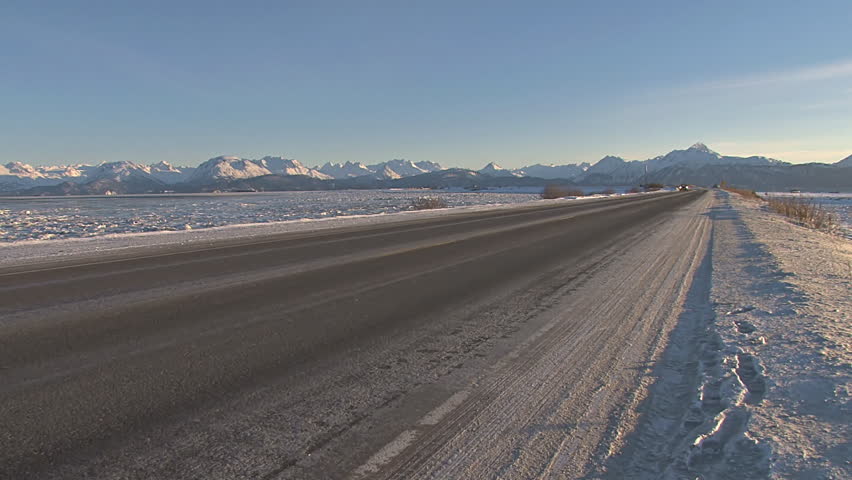 Pickup Truck Zooms Toward and Past Camera on Homer Spit Road in Winter on Clear