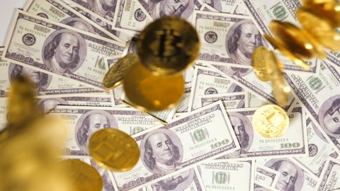 slow motion mined golden coins created by valuable resource bitcoin used as virtual currency fall on banknotes