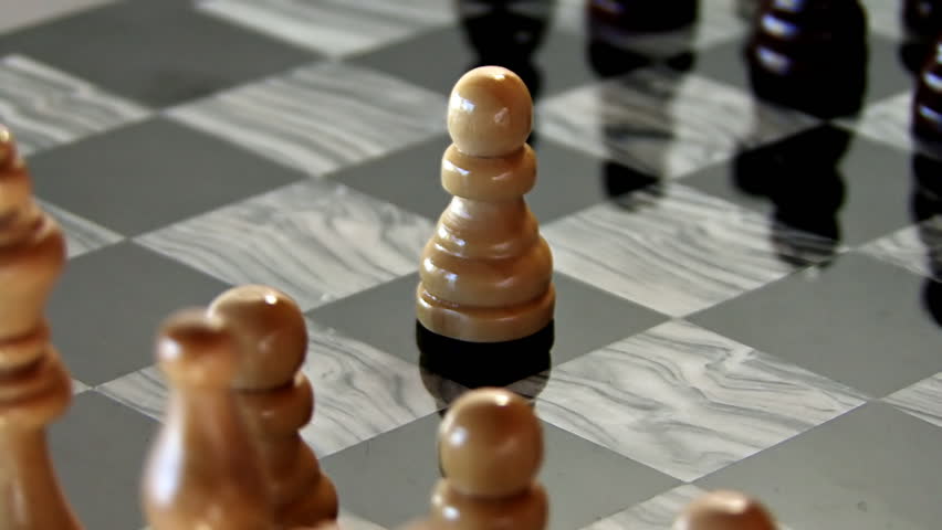 Opening move, wooden white pawn in center, chess, rotating marble chess board.
