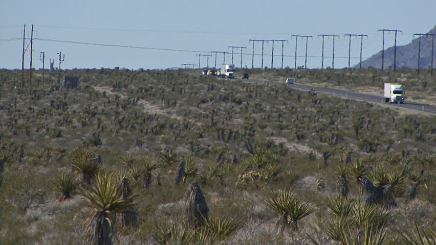 Wide long tele-shot of traffic on Nevada's Highway 93, heading northwest across