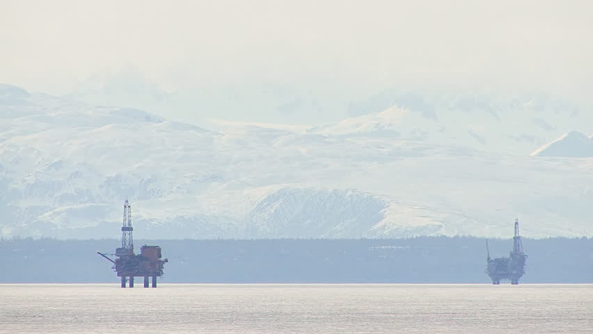 Two drilling platforms seen at great distance in Alaska's Cook Inlet.