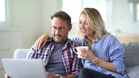 Mature couple connected on internet with laptop
