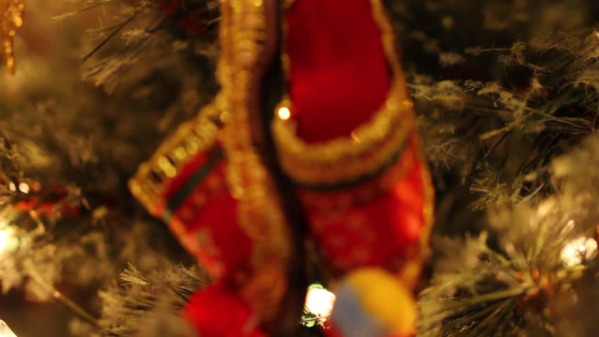 A woman decorates a small christmas tree in a house