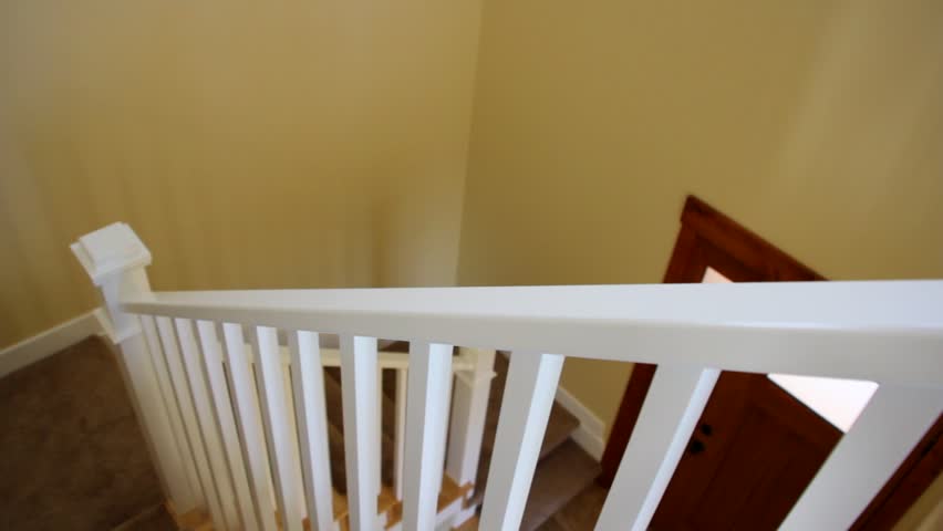 A dolly shot of carpeted stairs in a new home