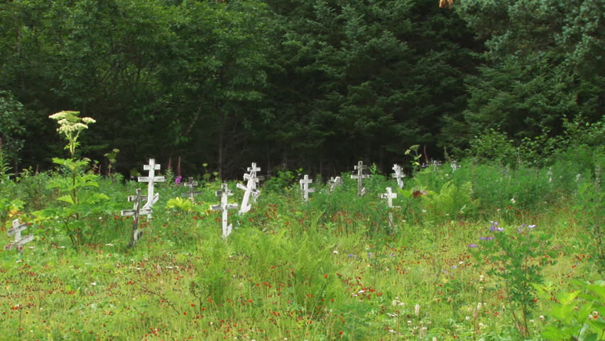 Panning right to left across a burial ground with timeworn crosses and