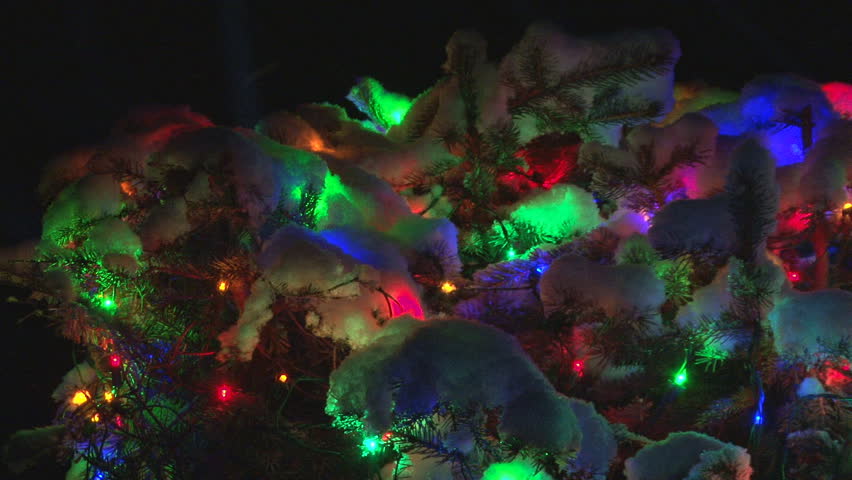 During a snowstorm, brilliant and colorful Xmas lights illuminate the snowy