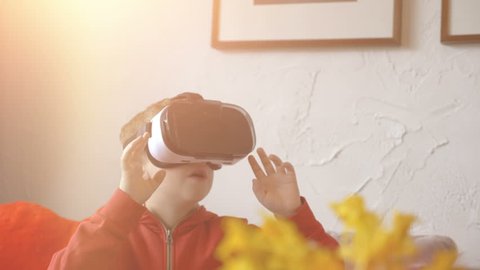 High quality video of child wearing virtual reality glasses and playing games in 4k in slow motion 60fps