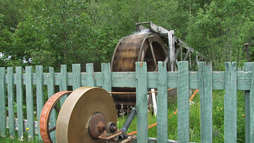 Shot of grindstone driven by waterwheel via pulleys and belt.