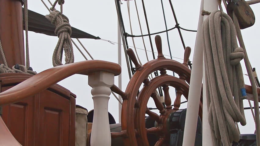 The helm of a contemporary square-rigger at harbor.