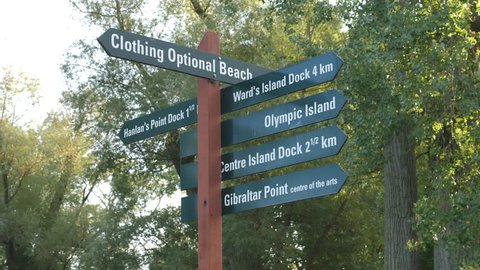 Toronto Islands sign including directions to clothing optional nude beach. Handheld shot with stabilized camera.
