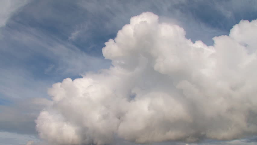 Billowing cumulus clouds in a strikingly rich blue sky. Time lapse.