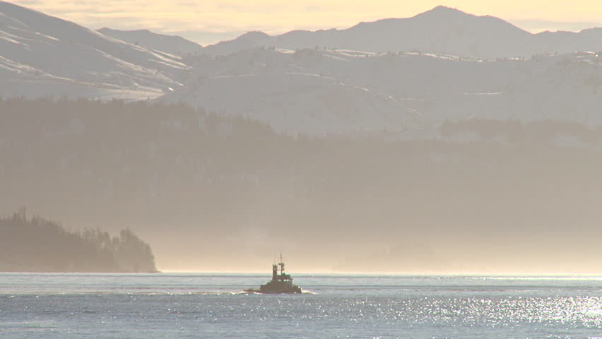 The stout and venerable tugboat heading into a late afternoon's glow over