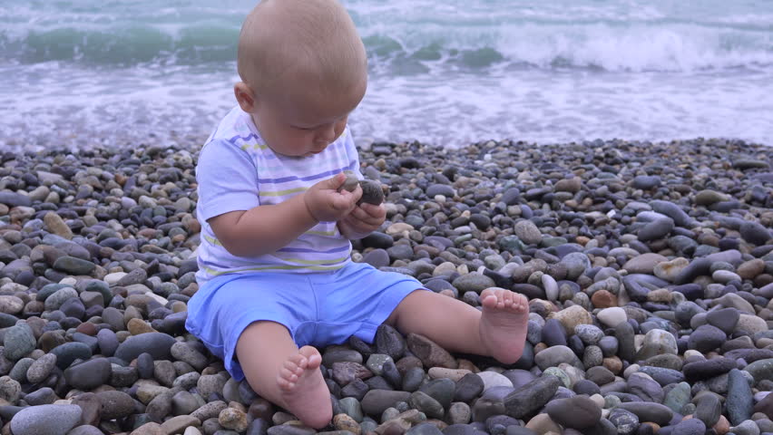 little child is sitting on a beach