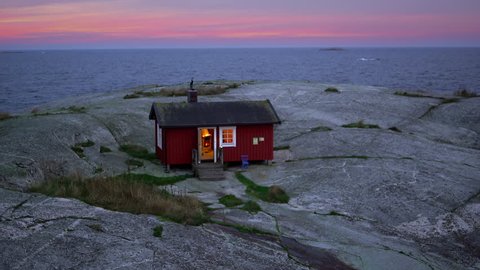 A small red cabin with a fireplace situated on an island in the Stockholm archipelago, Sweden
