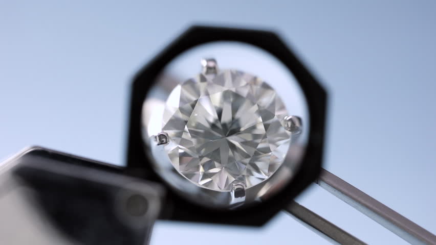 brilliant round diamond ring no flaw is being held by tweezers and looked through a 10x loupe Royalty-Free Stock Footage #31174813